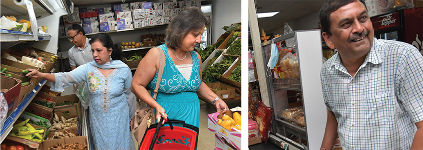 Women shopping in food market, a man smiling