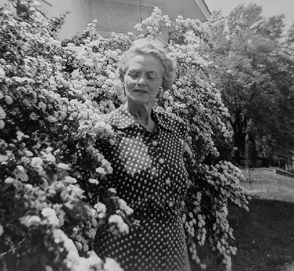 Woman in front of flowering bush