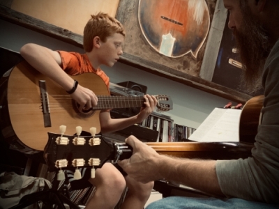 Dave McDonald gives guitar lessons to Calvin Edwards.