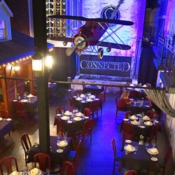 Shot from above the dinning room of "Connected" with store front facades and an air plane hanging from the ceiling
