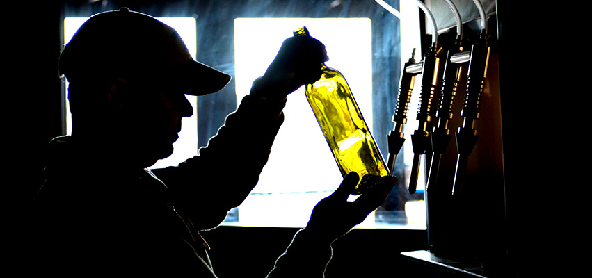Silhouette of Waters Edge Winery owner Mike Vandy filling a bottle of wine