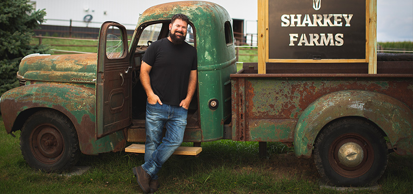 Rob Sharkey in Front of a Truck on Sharkey Farms