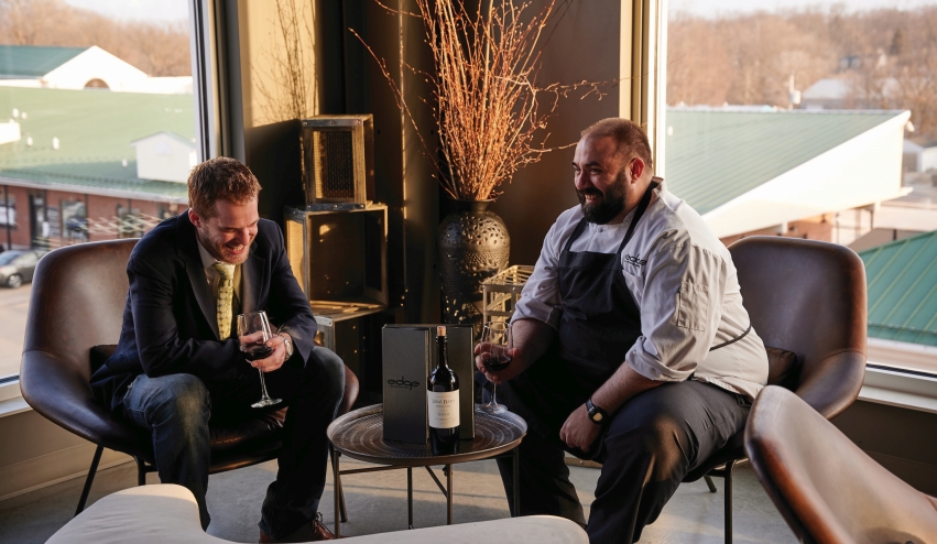 Chef Allen shares a glass of wine with Shane Harvey, at left, who manages the Twelve Bar on the third-floor above Edge.