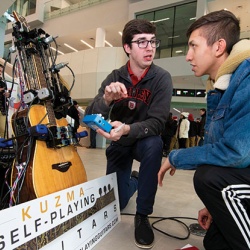 Inventor Michael Kuzma demonstrates his Kuzma Self-Playing Guitar system at an event at Bradley University.