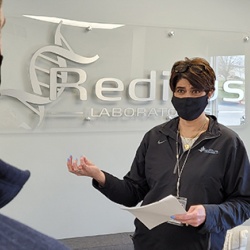 Halley holds a stand-up meeting with a Reditus staff member. Photo by Paul Swiech 